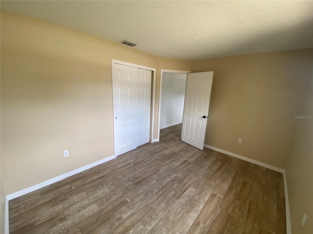11392 Beechdale Ave, Spring Hill, FL 34608 - unfurnished bedroom with wood finished floors, baseboards, and a closet
