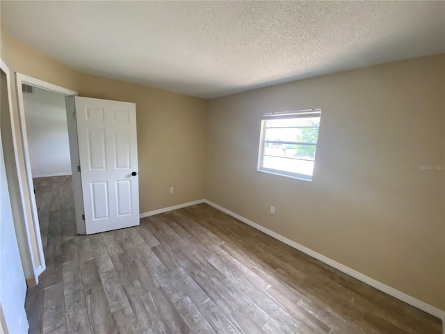 11392 Beechdale Ave, Spring Hill, FL 34608 - unfurnished room featuring a textured ceiling, wood finished floors, and baseboards