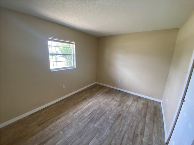 11392 Beechdale Ave, Spring Hill, FL 34608 - spare room with wood finished floors, a textured ceiling, and baseboards