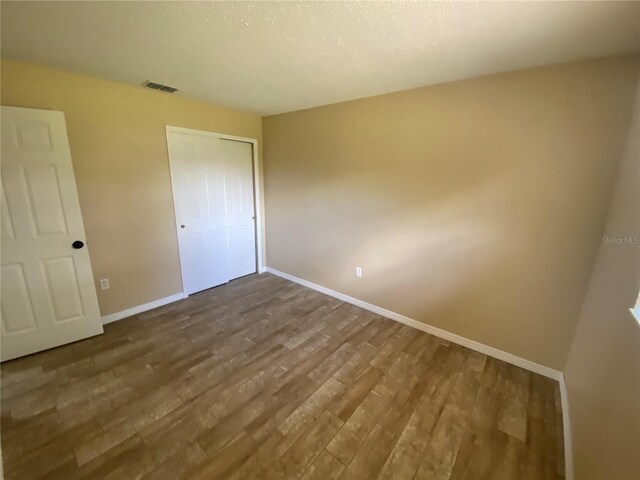 11392 Beechdale Ave, Spring Hill, FL 34608 - unfurnished bedroom featuring dark wood-type flooring, baseboards, and a closet