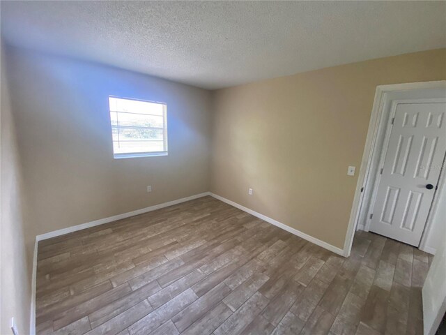 11392 Beechdale Ave, Spring Hill, FL 34608 - spare room featuring wood finished floors, a textured ceiling, and baseboards