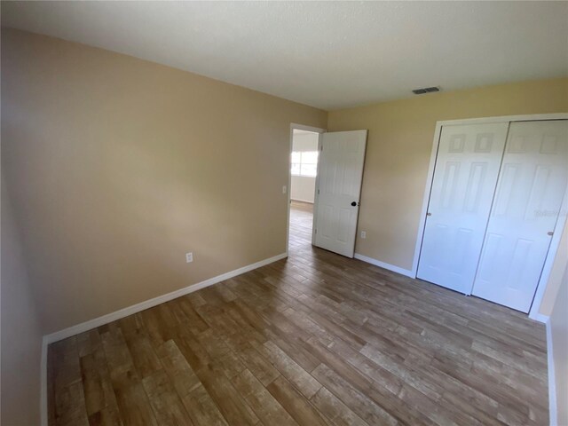 11392 Beechdale Ave, Spring Hill, FL 34608 - unfurnished bedroom featuring wood finished floors, baseboards, and a closet