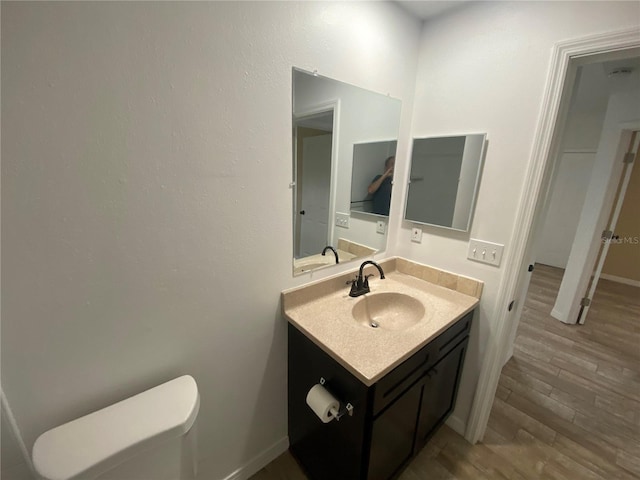 11392 Beechdale Ave, Spring Hill, FL 34608 - half bathroom featuring vanity, toilet, wood finished floors, and baseboards