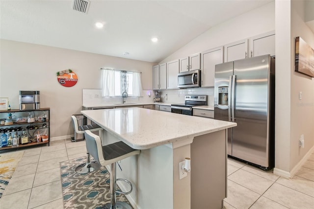 3886 Reflection Dock Dr, Seffner, FL 33584 - kitchen with stainless steel appliances, a sink, a kitchen island, tasteful backsplash, and vaulted ceiling