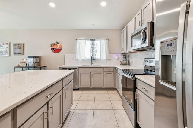3886 Reflection Dock Dr, Seffner, FL 33584 - kitchen with stainless steel appliances, backsplash, a sink, light stone counters, and light tile patterned floors