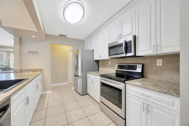 11291 Countrywood Ct, Spring Hill, FL 34609 - kitchen featuring stainless steel appliances, decorative backsplash, white cabinetry, and light tile patterned floors