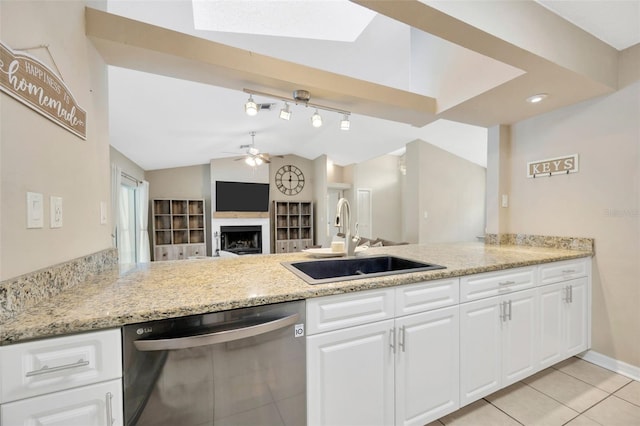 11291 Countrywood Ct, Spring Hill, FL 34609 - kitchen featuring dishwashing machine, a sink, a fireplace, ceiling fan, and vaulted ceiling