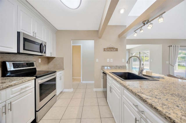 11291 Countrywood Ct, Spring Hill, FL 34609 - kitchen featuring stainless steel appliances, a sink, backsplash, baseboards, and white cabinetry