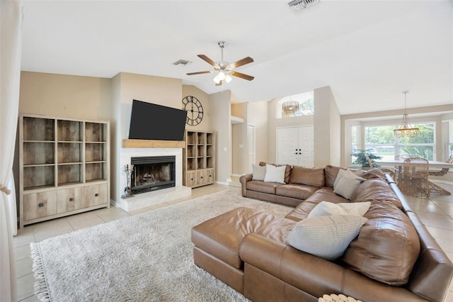 11291 Countrywood Ct, Spring Hill, FL 34609 - living room featuring tile patterned flooring, a ceiling fan, a fireplace with raised hearth, vaulted ceiling, and built in shelves