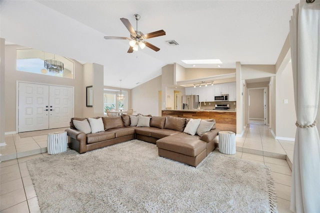11291 Countrywood Ct, Spring Hill, FL 34609 - living room featuring light tile patterned floors, lofted ceiling, a ceiling fan, baseboards, and a chandelier