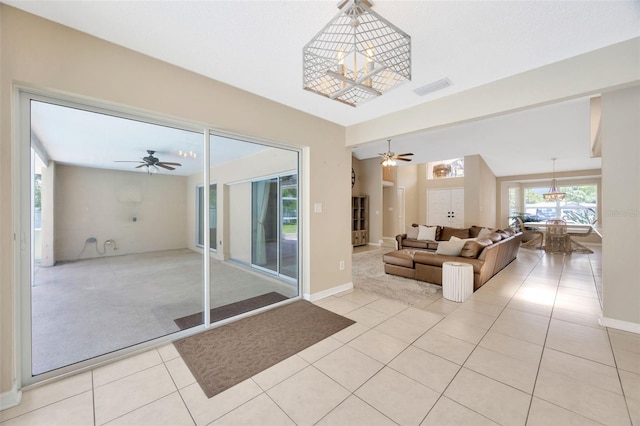 11291 Countrywood Ct, Spring Hill, FL 34609 - living area featuring a ceiling fan, light tile patterned floors, a chandelier, light colored carpet, and baseboards