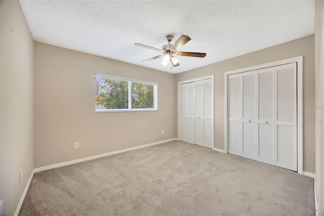 11291 Countrywood Ct, Spring Hill, FL 34609 - unfurnished bedroom featuring multiple closets, carpet flooring, baseboards, and a textured ceiling