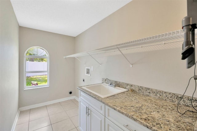 11291 Countrywood Ct, Spring Hill, FL 34609 - laundry area with hookup for a washing machine, hookup for an electric dryer, baseboards, light tile patterned floors, and cabinet space