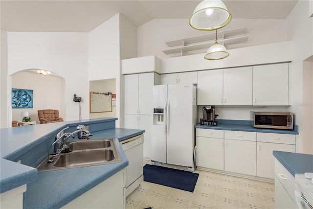 5423 Abagail Dr, Spring Hill, FL 34608 - kitchen featuring white appliances, arched walkways, white cabinetry, light flooring, and dark countertops