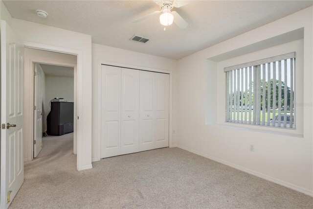 5423 Abagail Dr, Spring Hill, FL 34608 - unfurnished bedroom featuring light carpet, a closet, ceiling fan, and a textured ceiling