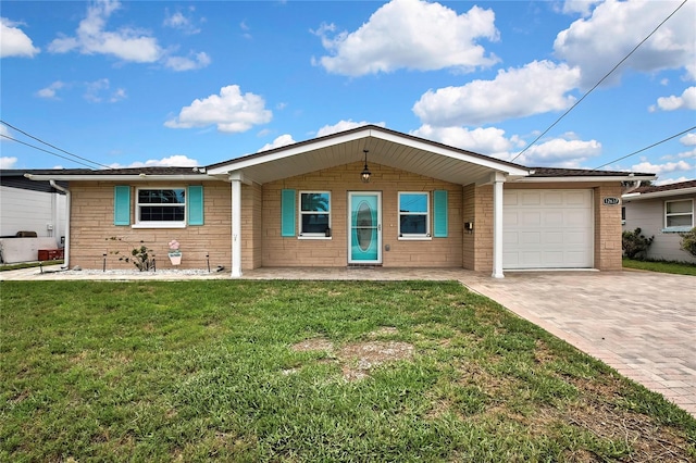 12637 2nd Isle, Hudson, FL 34667 - ranch-style home with decorative driveway, an attached garage, a front yard, and brick siding