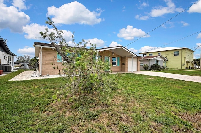 12637 2nd Isle, Hudson, FL 34667 - view of front of property featuring central air condition unit, driveway, a front yard, and an attached garage