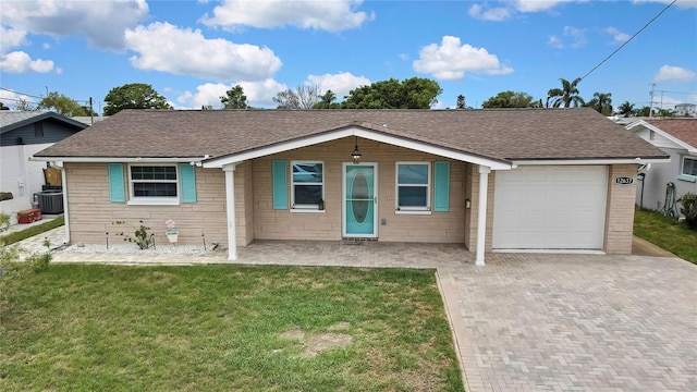 12637 2nd Isle, Hudson, FL 34667 - ranch-style home with cooling unit, a garage, a front yard, decorative driveway, and a shingled roof