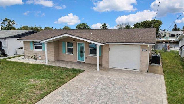 12637 2nd Isle, Hudson, FL 34667 - ranch-style house featuring an attached garage, roof with shingles, central AC, and decorative driveway