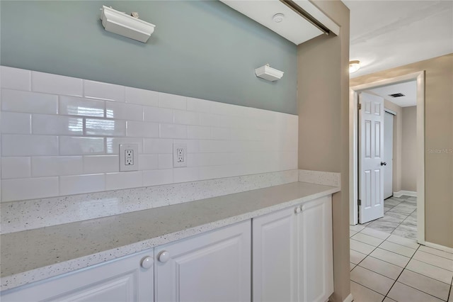12637 2nd Isle, Hudson, FL 34667 - kitchen with decorative backsplash, white cabinetry, and light stone counters