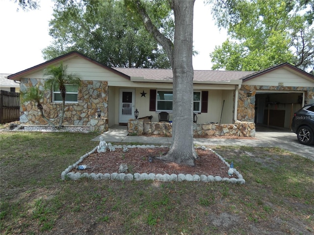 7421 Fairfax Dr, Port Richey, FL 34668 - ranch-style house featuring stone siding, a garage, driveway, and covered porch