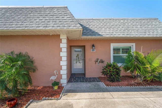 9622 Brassie Ct Unit 9, New Port Richey, FL 34655 - doorway to property featuring a shingled roof and stucco siding