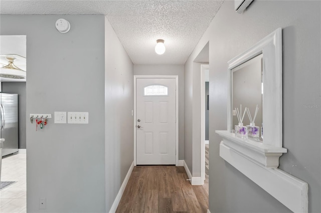 9622 Brassie Ct Unit 9, New Port Richey, FL 34655 - doorway featuring a textured ceiling, baseboards, wood finished floors, and a wall mounted air conditioner