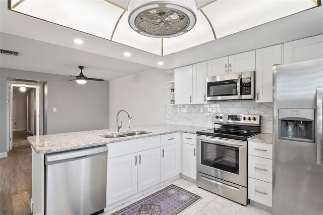 9622 Brassie Ct Unit 9, New Port Richey, FL 34655 - kitchen with appliances with stainless steel finishes, a sink, a peninsula, ceiling fan, and white cabinetry