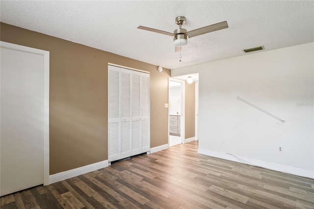 9622 Brassie Ct Unit 9, New Port Richey, FL 34655 - unfurnished bedroom with wood finished floors, baseboards, a textured ceiling, ceiling fan, and a closet