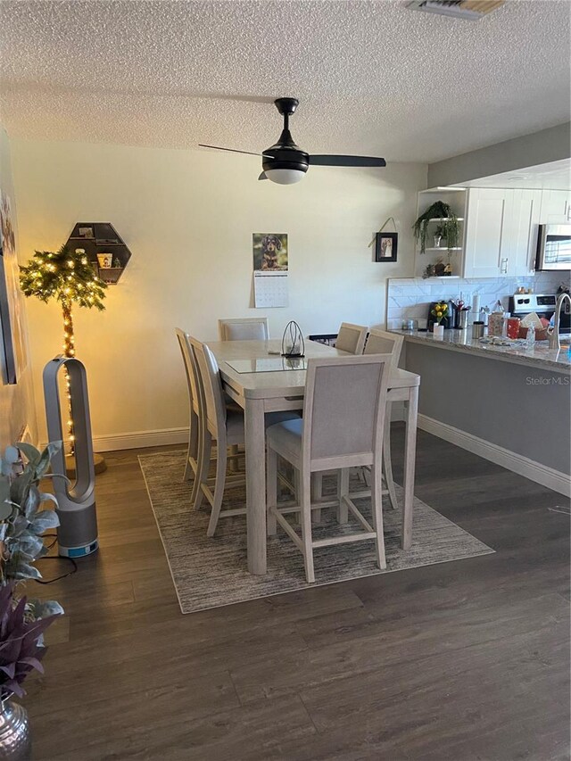 9622 Brassie Ct Unit 9, New Port Richey, FL 34655 - dining room featuring dark wood-style floors, a ceiling fan, a textured ceiling, and baseboards