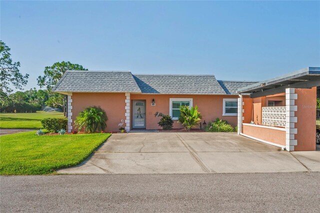 9622 Brassie Ct Unit 9, New Port Richey, FL 34655 - view of front facade with a shingled roof, mansard roof, stucco siding, and a front lawn