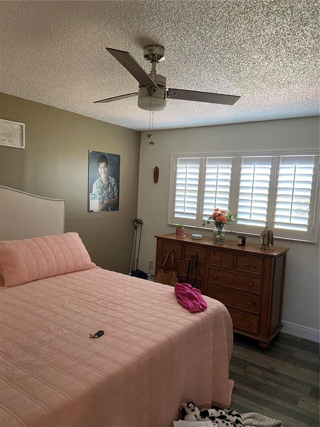 9622 Brassie Ct Unit 9, New Port Richey, FL 34655 - bedroom with dark wood-type flooring, a textured ceiling, ceiling fan, and baseboards