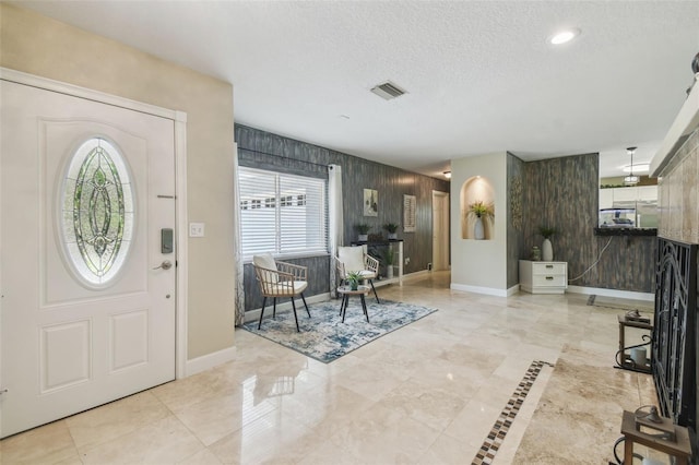 10301 Nina Ct, New Port Richey, FL 34654 - foyer entrance with plenty of natural light, baseboards, an accent wall, and a textured ceiling