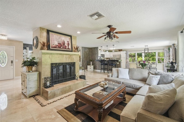 10301 Nina Ct, New Port Richey, FL 34654 - living room featuring a textured ceiling, a premium fireplace, ceiling fan, light tile patterned flooring, and recessed lighting