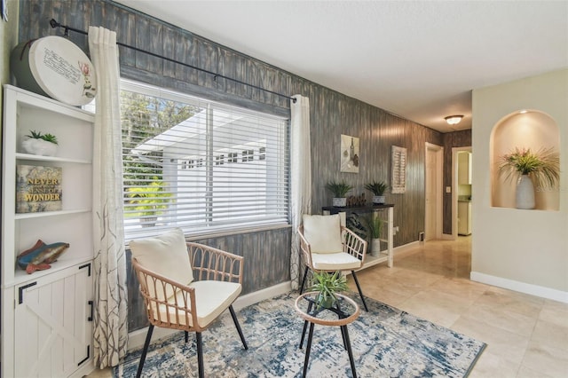 10301 Nina Ct, New Port Richey, FL 34654 - living area featuring baseboards, wooden walls, and tile patterned floors