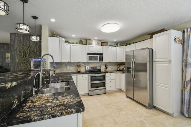 10301 Nina Ct, New Port Richey, FL 34654 - kitchen with appliances with stainless steel finishes, a sink, white cabinets, tasteful backsplash, and a textured ceiling