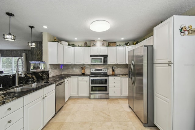 10301 Nina Ct, New Port Richey, FL 34654 - kitchen with appliances with stainless steel finishes, a sink, decorative backsplash, a textured ceiling, and white cabinetry