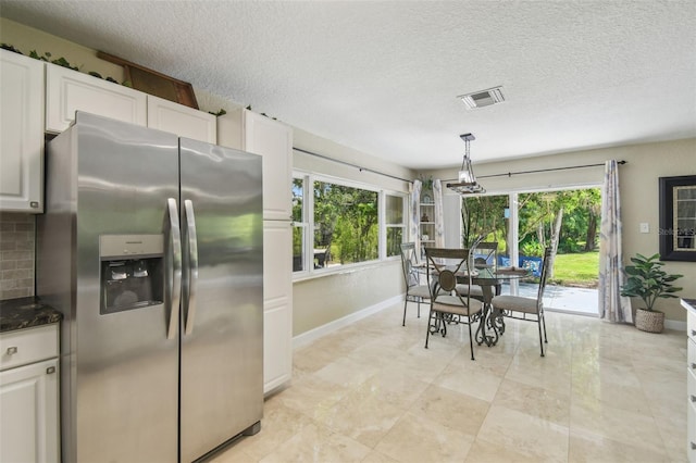 10301 Nina Ct, New Port Richey, FL 34654 - dining room with healthy amount of natural light, baseboards, a textured ceiling, and a chandelier