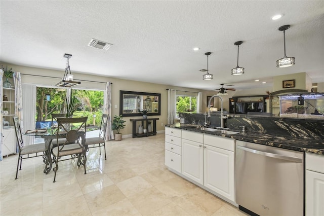 10301 Nina Ct, New Port Richey, FL 34654 - kitchen with stainless steel dishwasher, a textured ceiling, a ceiling fan, plenty of natural light, and white cabinets