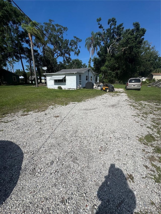 410 Houle Ave, Sarasota, FL 34232 - view of side of property featuring gravel driveway and a yard