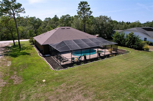 9152 Bunting Rd, Weeki Wachee, FL 34613 - outdoor pool featuring a patio, a lawn, and glass enclosure