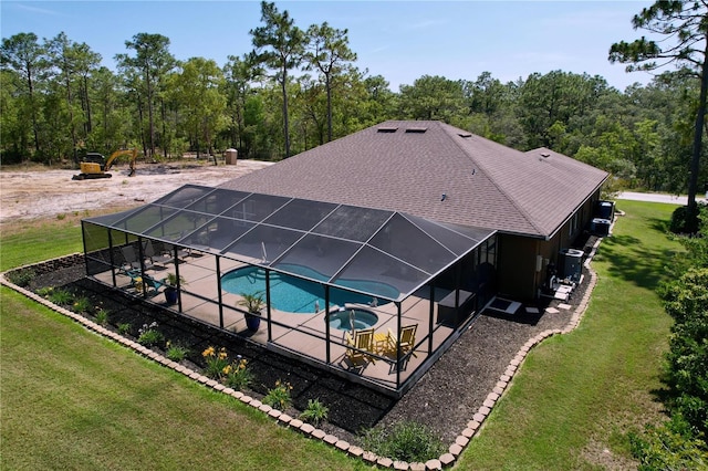 9152 Bunting Rd, Weeki Wachee, FL 34613 - view of swimming pool featuring a patio, a lawn, a pool with connected hot tub, and glass enclosure