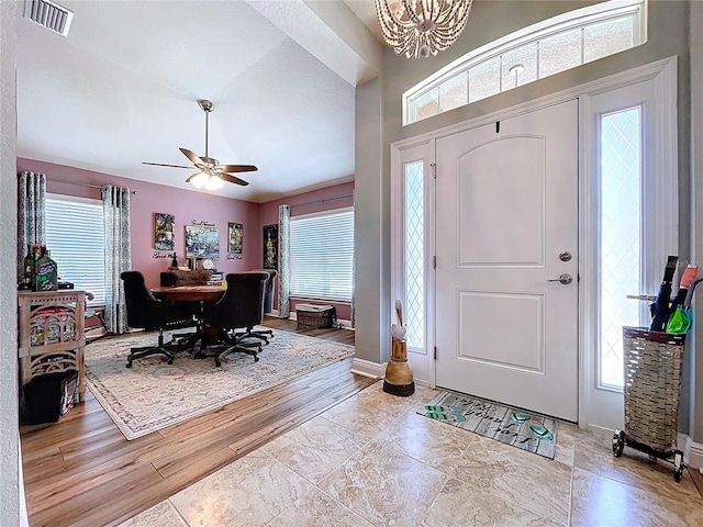 9152 Bunting Rd, Weeki Wachee, FL 34613 - entryway with ceiling fan, wood finished floors, a chandelier, and baseboards