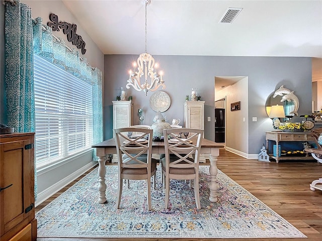 9152 Bunting Rd, Weeki Wachee, FL 34613 - dining space featuring a chandelier, wood finished floors, and baseboards