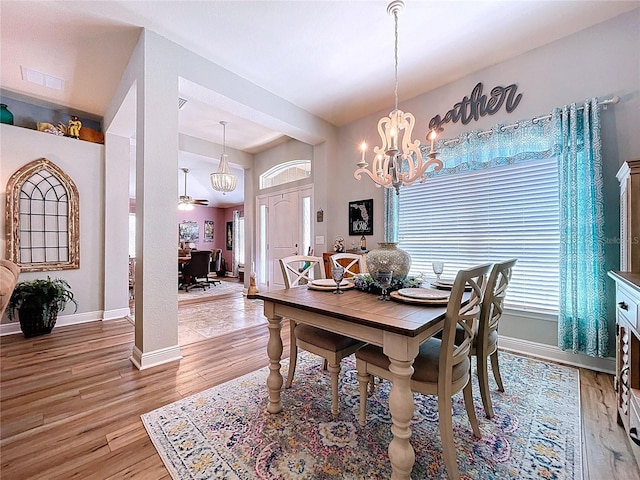 9152 Bunting Rd, Weeki Wachee, FL 34613 - dining room with plenty of natural light, baseboards, a chandelier, and light wood-style flooring