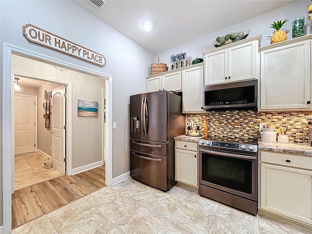 9152 Bunting Rd, Weeki Wachee, FL 34613 - kitchen with appliances with stainless steel finishes, decorative backsplash, baseboards, and vaulted ceiling