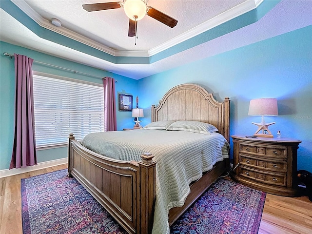 9152 Bunting Rd, Weeki Wachee, FL 34613 - bedroom with crown molding, wood finished floors, a tray ceiling, a ceiling fan, and baseboards