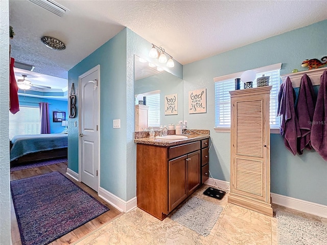 9152 Bunting Rd, Weeki Wachee, FL 34613 - full bathroom featuring a textured ceiling, ensuite bathroom, vanity, plenty of natural light, and baseboards