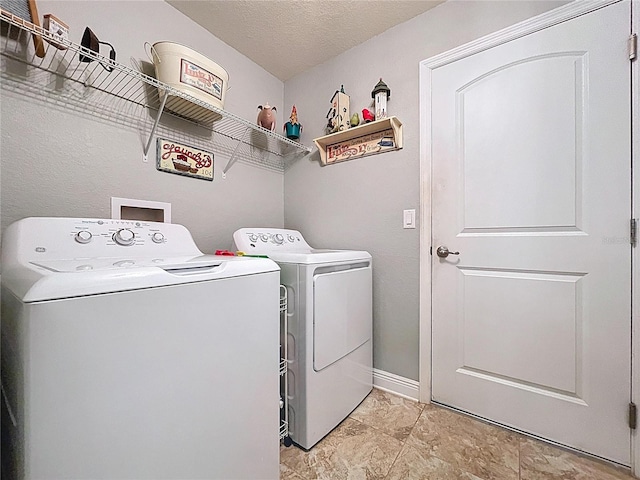 9152 Bunting Rd, Weeki Wachee, FL 34613 - laundry room with washing machine and clothes dryer, a textured ceiling, and baseboards