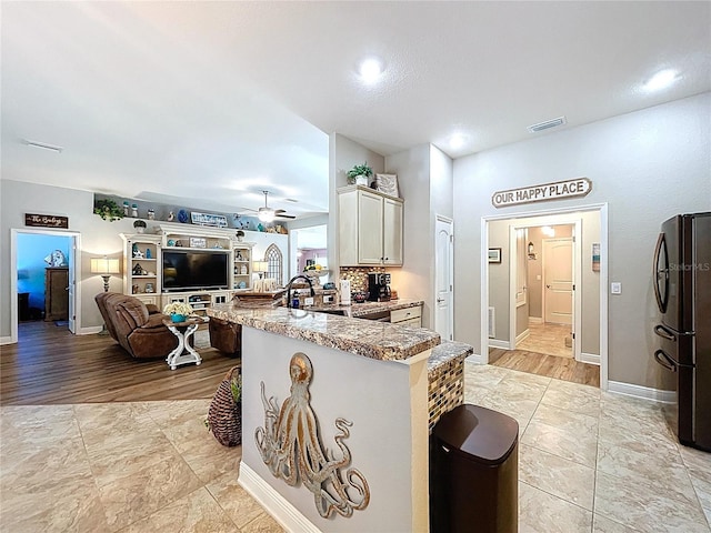 9152 Bunting Rd, Weeki Wachee, FL 34613 - kitchen with freestanding refrigerator, a peninsula, a ceiling fan, open floor plan, and baseboards